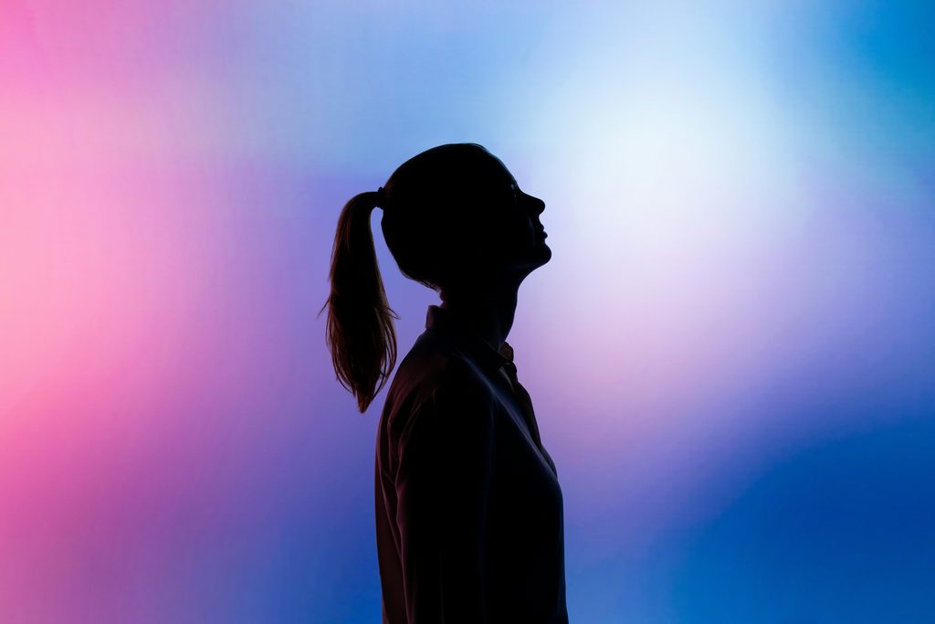 La silhouette d’une personne de profil se détache sur un fond en dégradé coloré