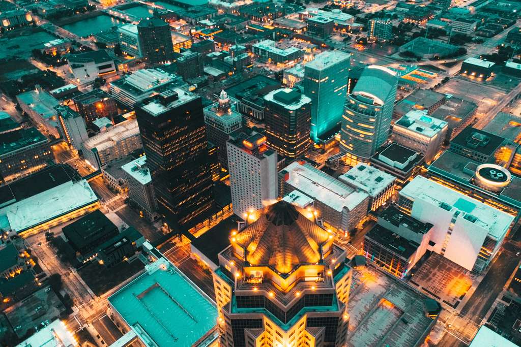 Aerial view of a city lit up at night, in turquoise tones